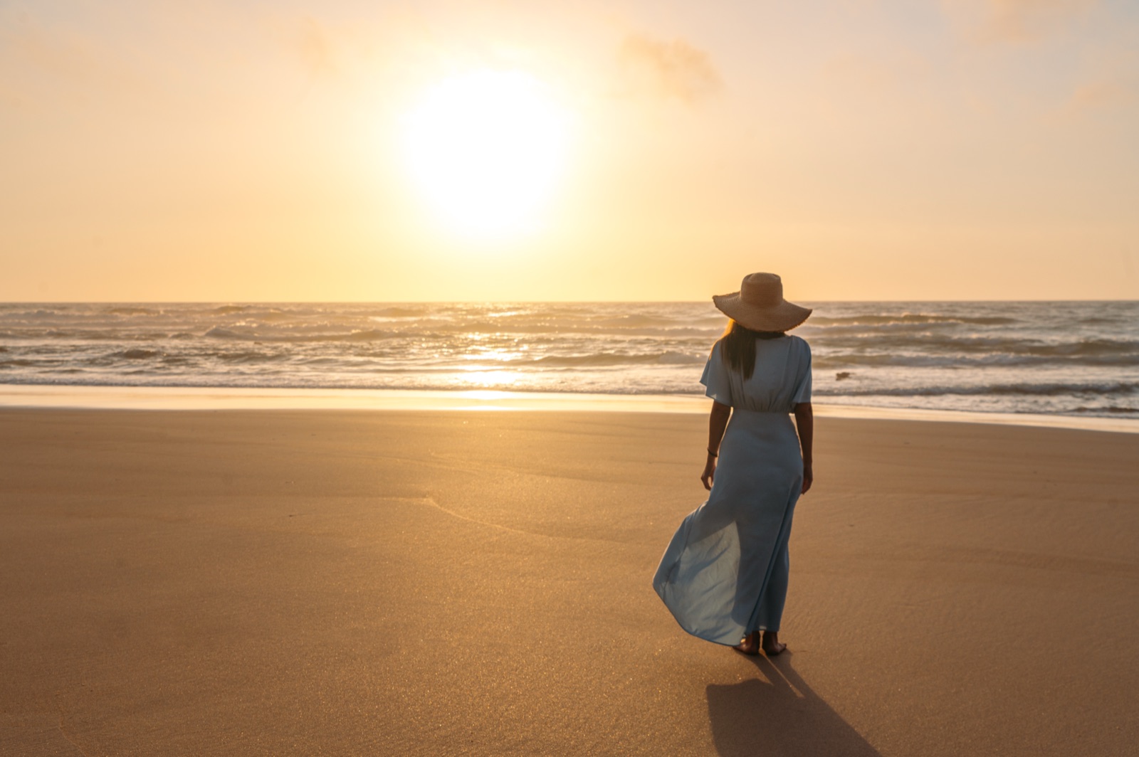 A woman walking on the beach at sunset in Puerto Vallarta